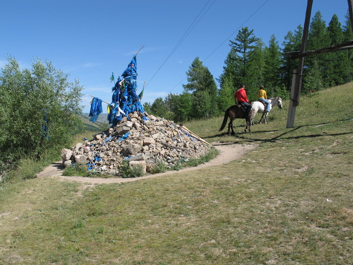 Prayer flags and a pile of offering stones at the top of a pass.