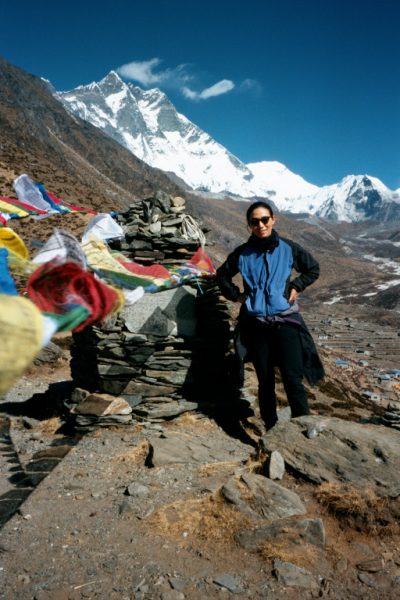 Liyang taking a break near a few Tibetan prayer flags.