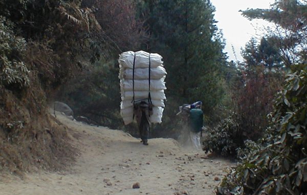 A port carries a load up the hill to Namche bazaar.