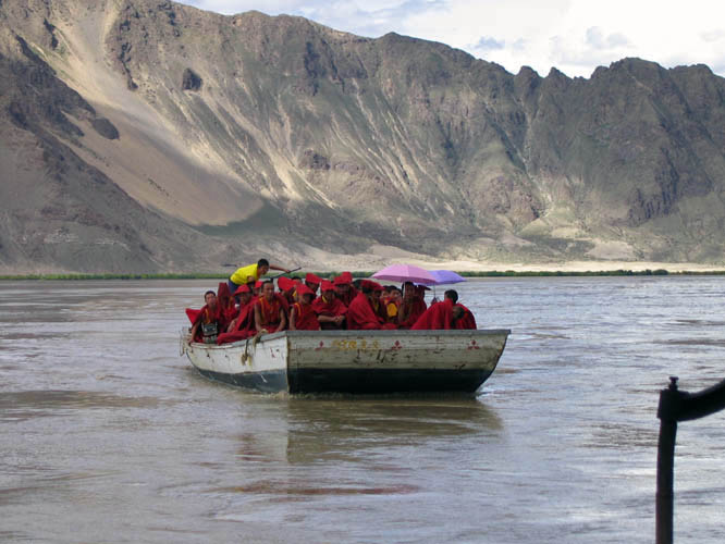 Monks crossing the Bramaputra river by local ferry.