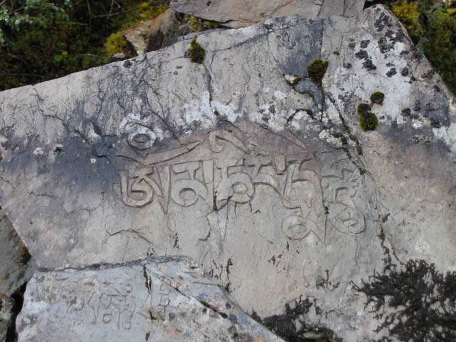 The mantra of the Buddha of compassion written on a stone found near the trail side.