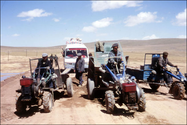As we got further into Tibet the roads quickly deteritated into large patches of mud. These gentlemen on the tractors are the local road repair crew. Amdo, Tibet.