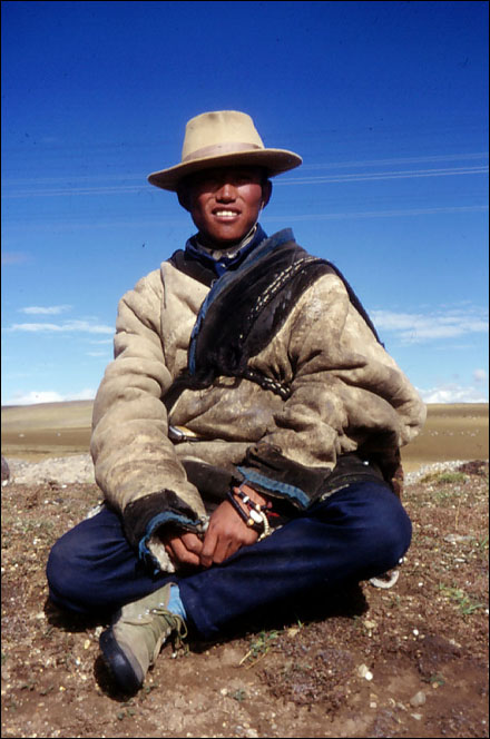Tibetan nomad kids spend their days taking care of the sheep and relaxing on the roadside. Amdo, Tibet.