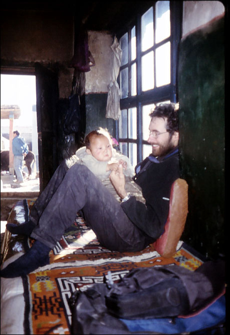 John preparing for fatherhood with a Tibetan new born.Tingre, Tibet.
