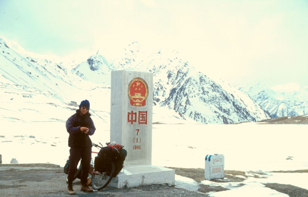 Liyang at the the top of the Kunjarab Pass, the stone pillar marks the border between Pakistan and China.