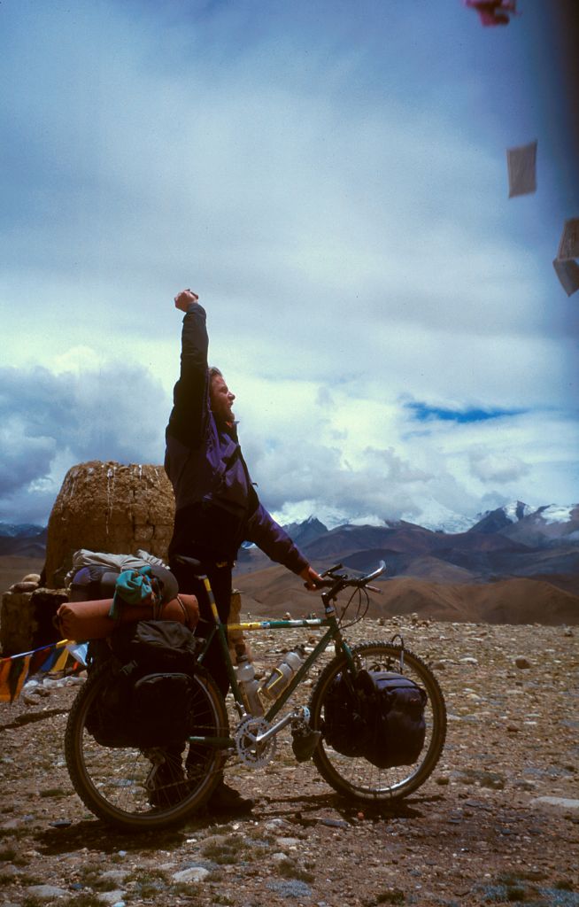 Ray, releasing a hand full of small paper prayer flags a top the last mountain pass of the journey. La Lung La, Tibet. 